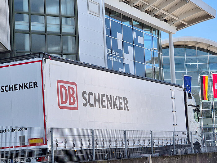 LKW mit der Aufschrift "DB Schenker" vor den Messehallen